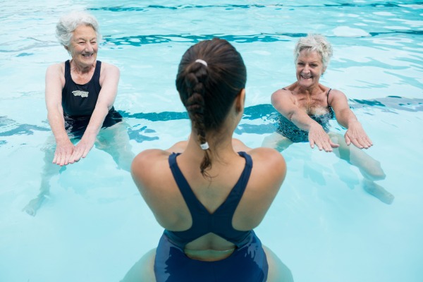 swimming pool exercise - women doing squats in the water